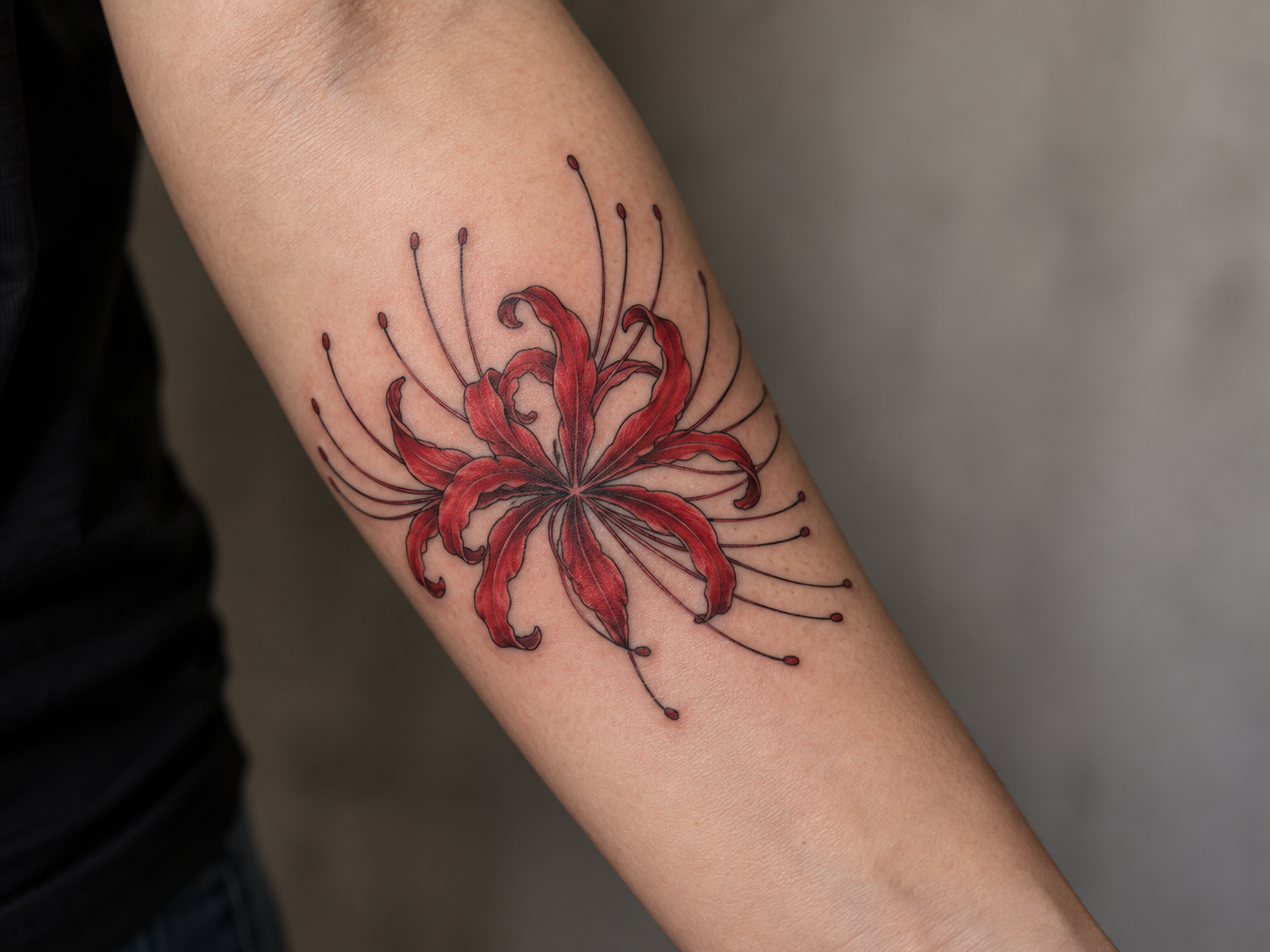 Red spider lily tattoo on a forearm with fine-line petals and radiating stamens